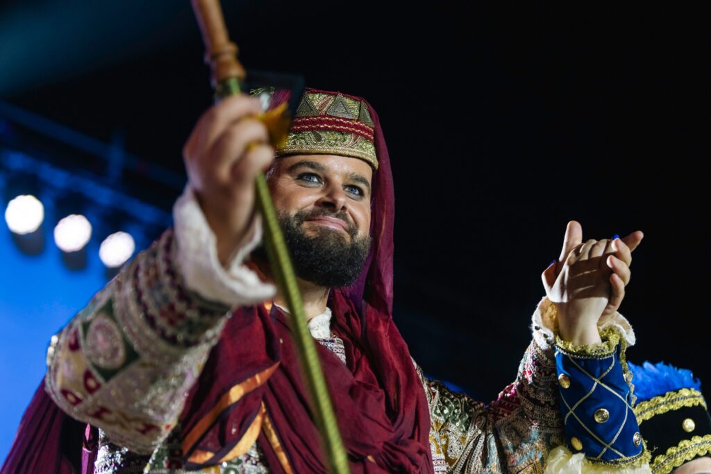 Rey moro con traje de burdeos y oro durante un acto festero de Villajoyosa.